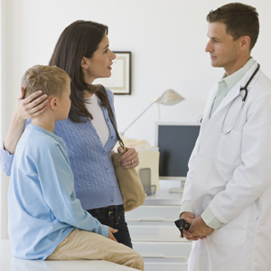 A boy and mother talk to a male healthcare provider.