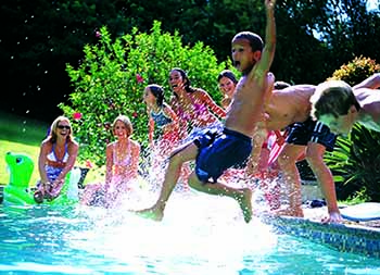 a bunch of kids jumping into a swimming pool