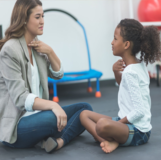 Child sitting with a speech therapist.