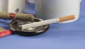 Cigarette and cigar in ashtray.