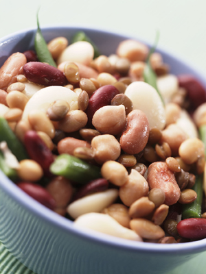Close-up of many varieties of cooked beans in a bowl.