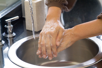 Close up view of hands being washed.