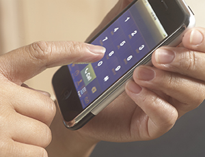 Closeup of hands holding cell phone.