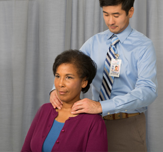 Doctor doing a thyroid check on woman