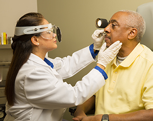 Doctor examining man’s nose.