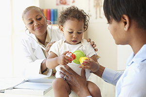 Doctor talking to mother and daughter in doctor's office.