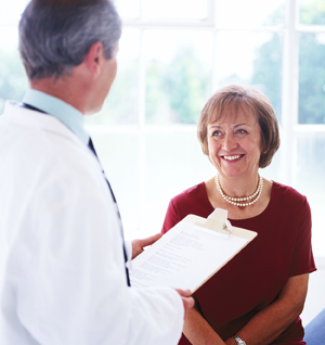 Doctor talking with middle aged female patient.