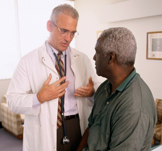 Doctor talking with older man in medical office
