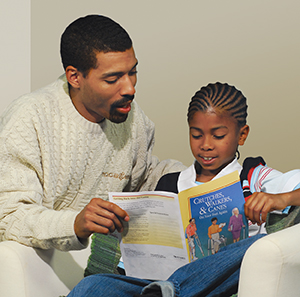 Man reading booklet with boy.