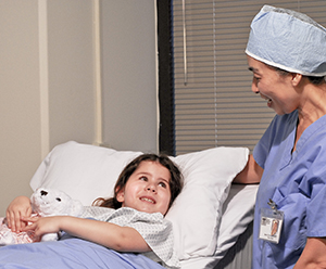 Health Care profressional talking with little girl in hospital.