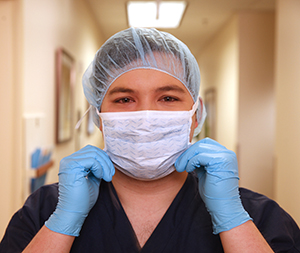 Healthcare provider putting mask over nose and mouth.