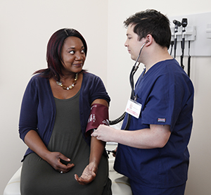 Healthcare provider taking woman's blood pressure.