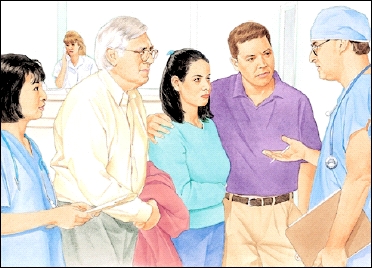 Health care provider talking to family in hospital waiting room.