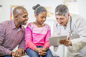 Healthcare provider talking to girl and woman.