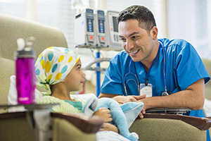 Healthcare provider talking with girl receiving chemotherapy.