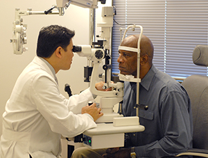 Heathcare provider examining man's eyes.