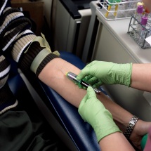 Lab technician drawing blood from patient's arm
