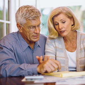 Man and woman sitting at table looking at paperwork.