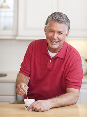 Man eating yogurt in the kitchen