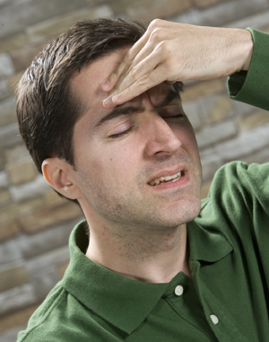 Man holding hand to forehead, looking distressed.