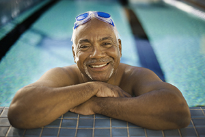 Man in swimming pool, smiling.
