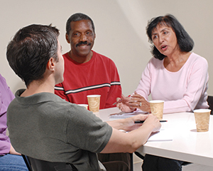 Man talking with counselor and support group.