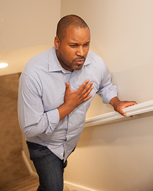 Man walking upstairs holding hand to chest.