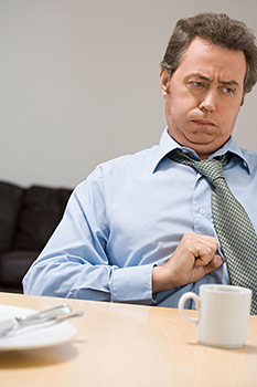 MAn with stomach upset holding his hand to his belly