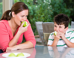 Mother and son eating apples.