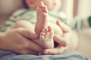 Mother holding tiny baby feet.