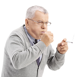 Older man with a cigarette in his hand, hunched over coughing into his other hand.