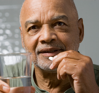 Older man with pill and glass of water