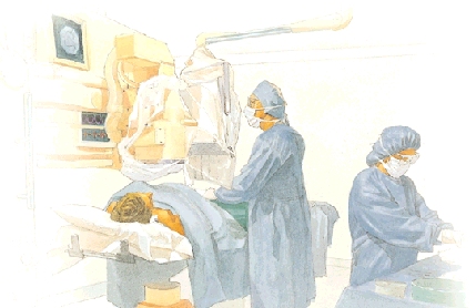 Person lying on table underneath x-ray machine. Person is covered with hospital blankets. Healthcare provider with surgical gown, gloves, hat, and mask are standing at side of table performing procedure, looking at video monitor. Another healthcare provider is working at side table.