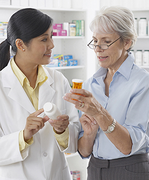 Pharmacist talking to woman about pills.