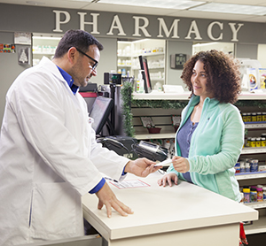 Pharmacist talking to woman at pharmacy counter.