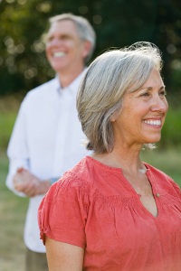 Photo of a smiling middle-aged woman with man in background