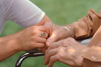 Picture of an elderly woman and younger woman holding hands