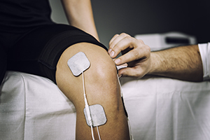 TENS electrodes positioned to treat knee pain in physical therapy