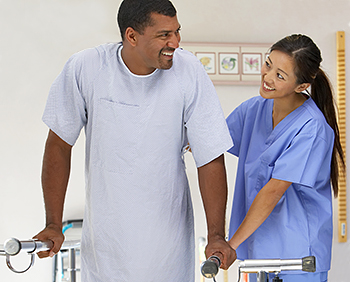 Therapist helping man walk