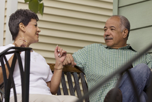 Woman and man sitting outdoors together, talking.