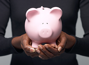 Woman hands holding a piggy bank.