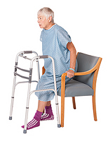 Woman lowering herself into chair - keeping operated leg slightly out in front.