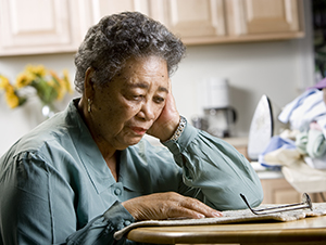 Woman sitting at a table looking depressed.