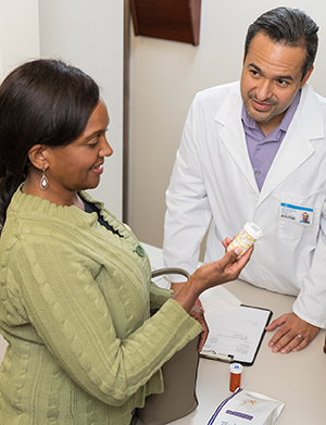 Woman talking to pharmacist at pharmacy counter.