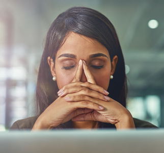 Woman with her eyes closed, as though in pain