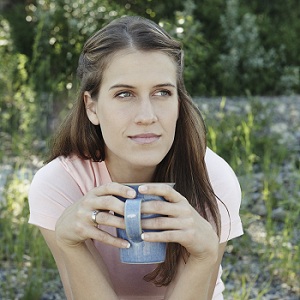 Young woman holding cup of coffee outdoors
