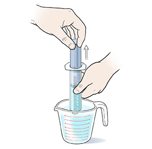 Closeup of hands drawing water into twist-on syringe from measuring cup.