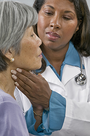 Healthcare provider examining woman's neck.