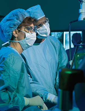 Two doctors operating on patient.