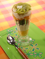 Stacked fruit salad in a tall ice cream glass.